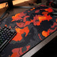 Mouse pad with fiery design on a desk next to a keyboard
