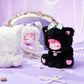 Black plush toy with pink accents and a white mirror on a purple background