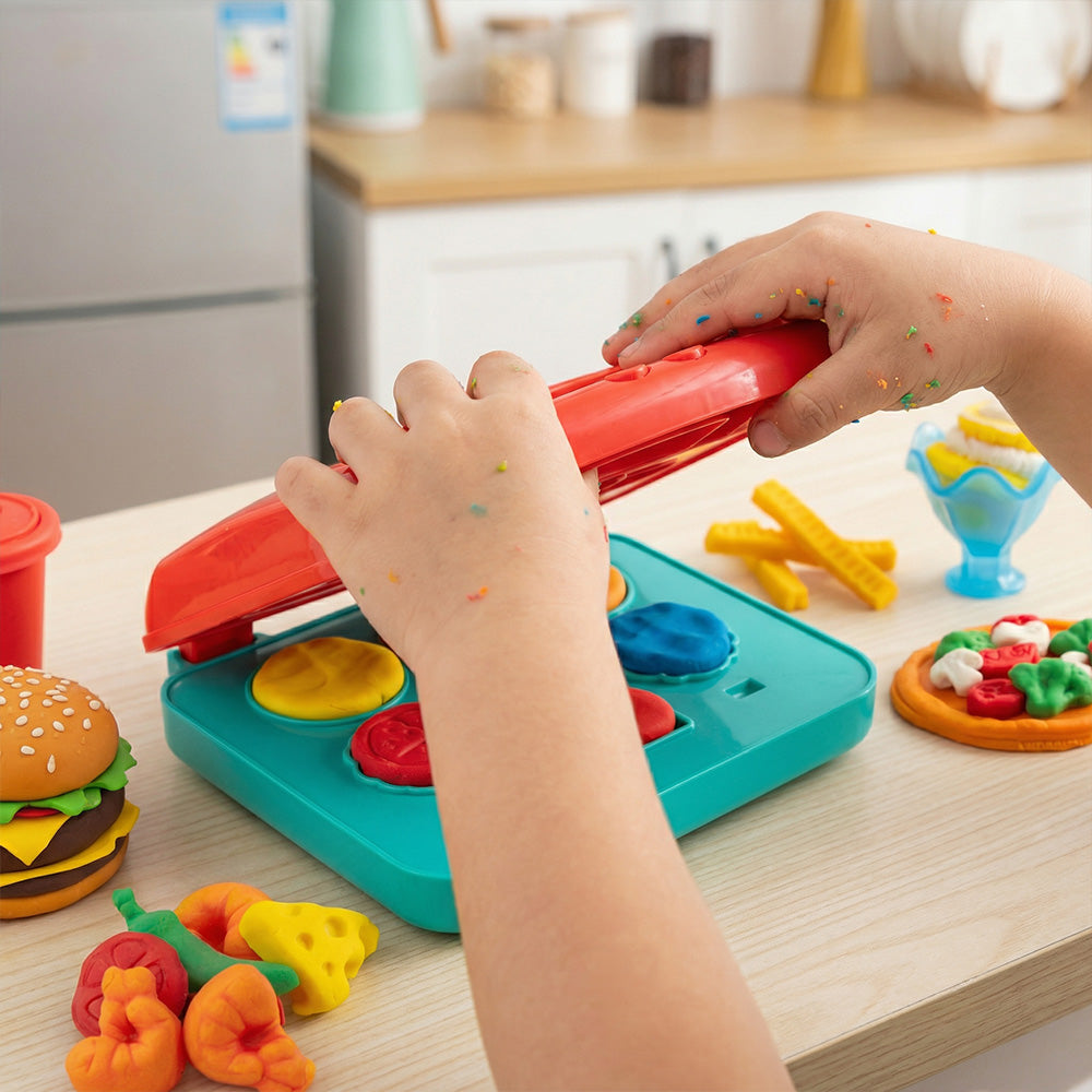 Child playing with colorful toy kitchen set on a kitchen counter.