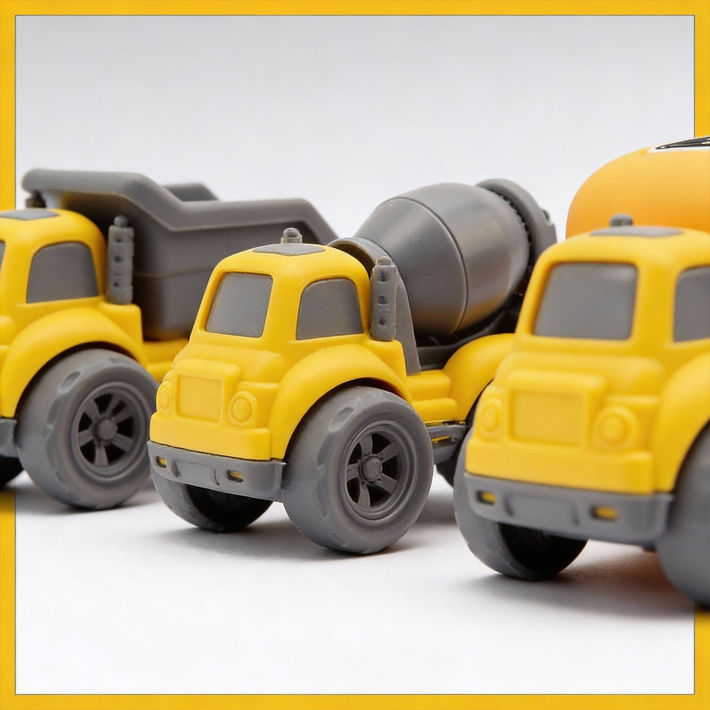 Toy construction vehicles including a dump truck, cement mixer, and bulldozer on a light gray background.