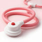 Pink and white toy with a red button 