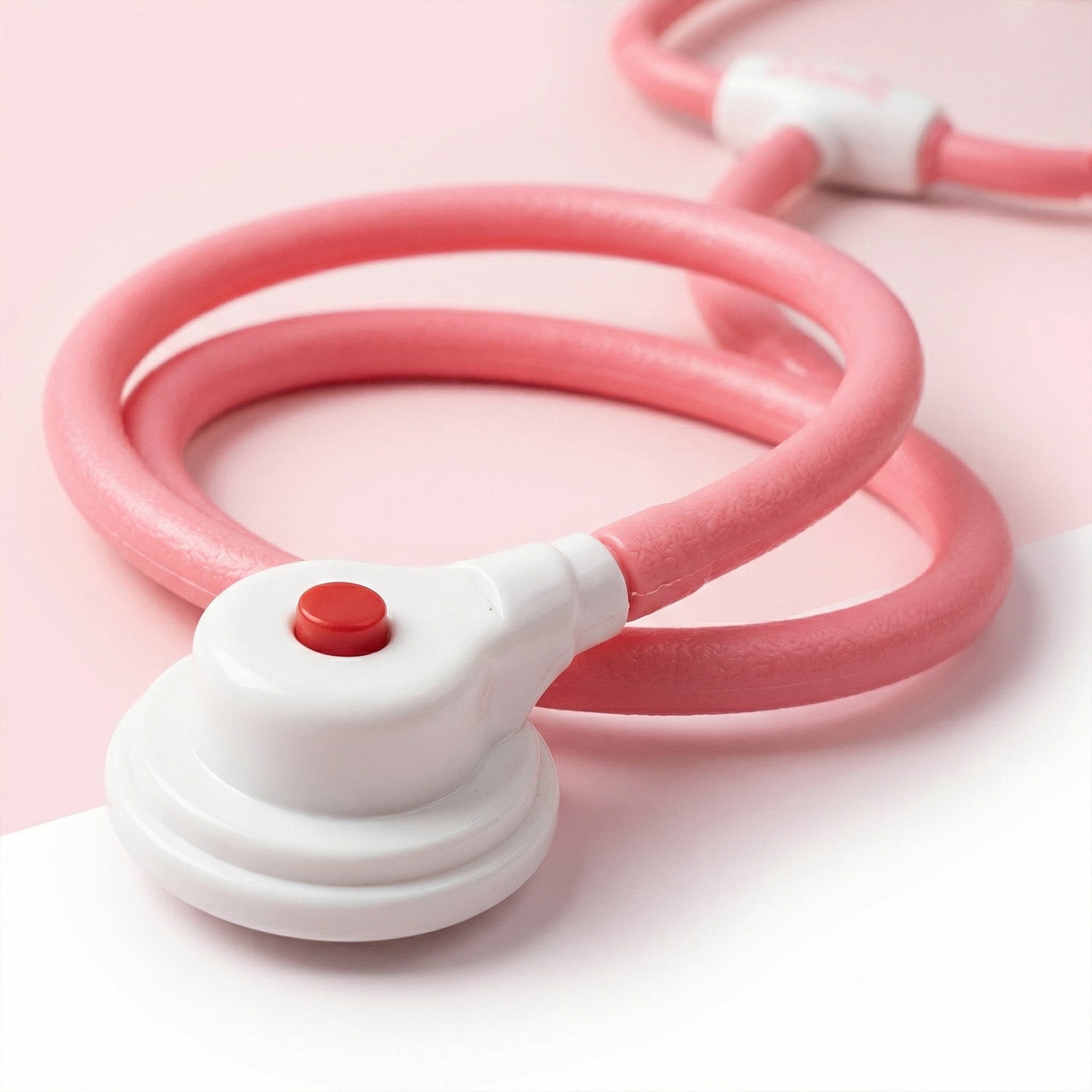 Pink and white toy with a red button 