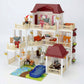 Toy dollhouse with multiple levels, furniture, and small figures 
